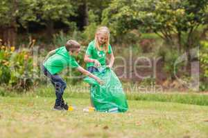 Happy siblings collecting rubbish