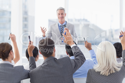 Business people raising their arms during meeting