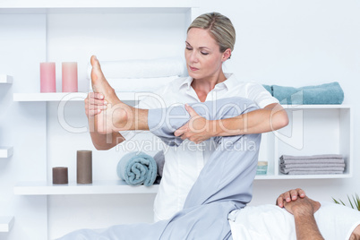 Physiotherapist doing leg massage to her patient