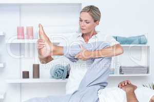 Physiotherapist doing leg massage to her patient