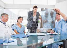 Team of doctors and businesswoman examining xray