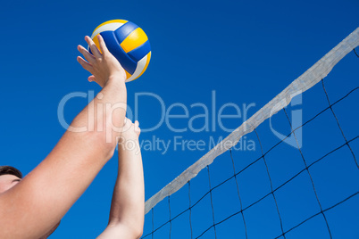 Man throwing volleyball above the net