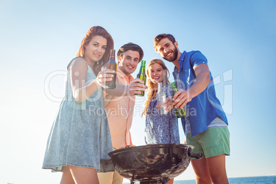 Happy friends doing barbecue and drinking beer