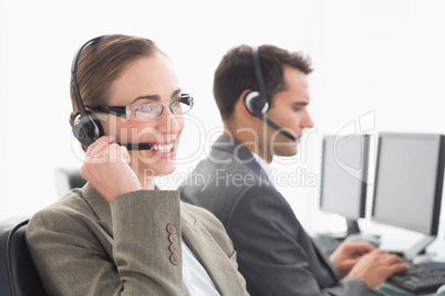 Business people with headsets using computers