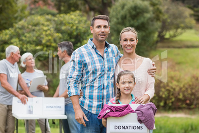 Happy family holding boxes and smiling at the camera