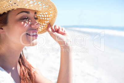 Brunette sitting in the sand and looking at the sea