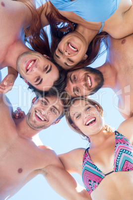Group of friends standing in circle and smiling at camera