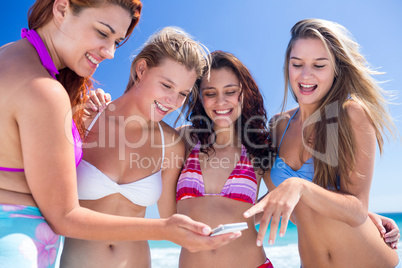 Happy friends looking at smartphone