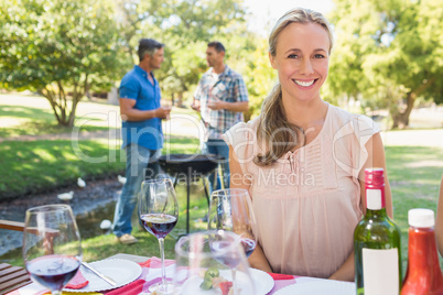 Happy blonde smiling at camera in the park
