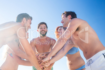 Group of friends standing in circle hands together