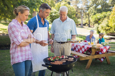 Happy man doing barbecue for his family