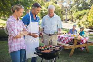 Happy man doing barbecue for his family