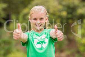 Happy little girl in green with thumbs up