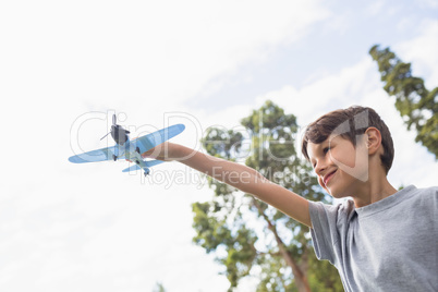 Boy playing with a toy plane at park