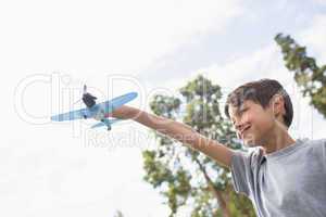 Boy playing with a toy plane at park