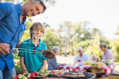 Happy father doing barbecue with his son