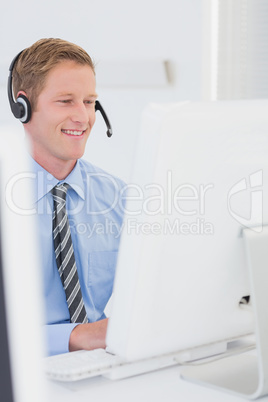 Handsome agent with headset typing on keyboard