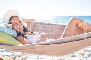 Brunette relaxing in the hammock and smiling at camera