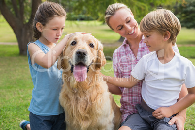 Happy family playing with their dog