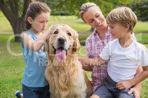 Happy family playing with their dog