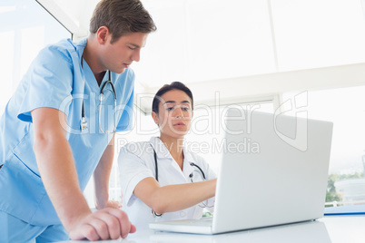 Doctors working on laptop computer