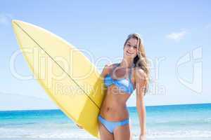 Pretty blonde woman holding surf board