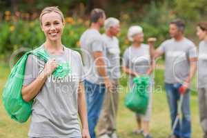 Happy volunteer collecting rubbish