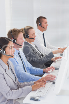 Business team working on computers and wearing headsets Business team working on computers and wearing headsets