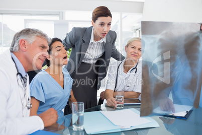 Team of doctors and businesswoman examining xray