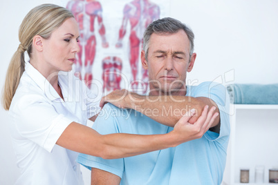 Doctor stretching a man arm