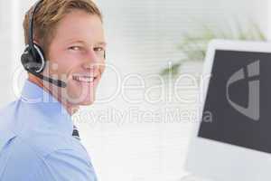 Handsome agent with headset typing on keyboard