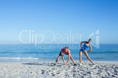 Happy couple stretching together beside the water