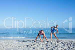 Happy couple stretching together beside the water