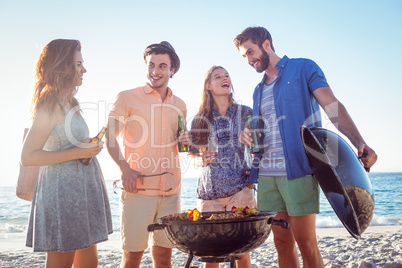 Happy friends doing barbecue and drinking beer