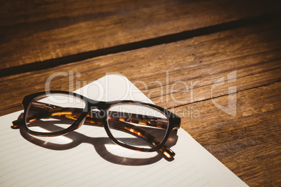 Empty notepad with reading glasses