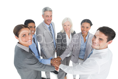 Executives holding hands together in office