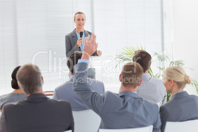 Pretty businesswoman talking in microphone during conference