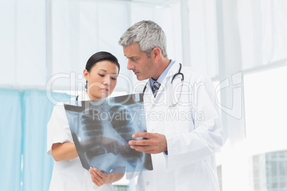 Male and female doctors examining x-ray