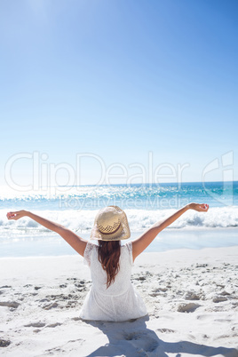 Brunette sitting in the sand and enjoying the air