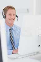 Handsome agent with headset typing on keyboard