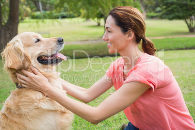 Pretty brunette with her dog in the park