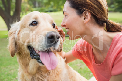 Pretty brunette with her dog in the park