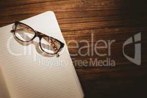 Empty notepad with reading glasses