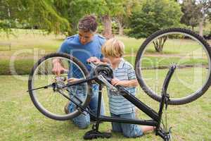 Father and his son fixing a bike