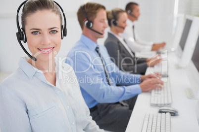 Business team working on computers and wearing headsets