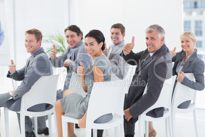 Smiling business team looking at camera during conference