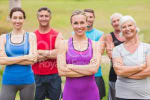 Happy athletic group smiling at camera with hands crossed