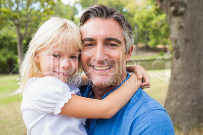 Happy father smiling at camera with his daughter