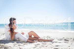 Happy couple relaxing together in the sand