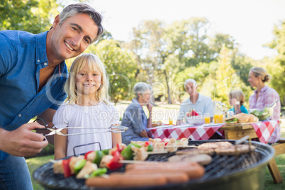 Happy father doing barbecue with her daughter